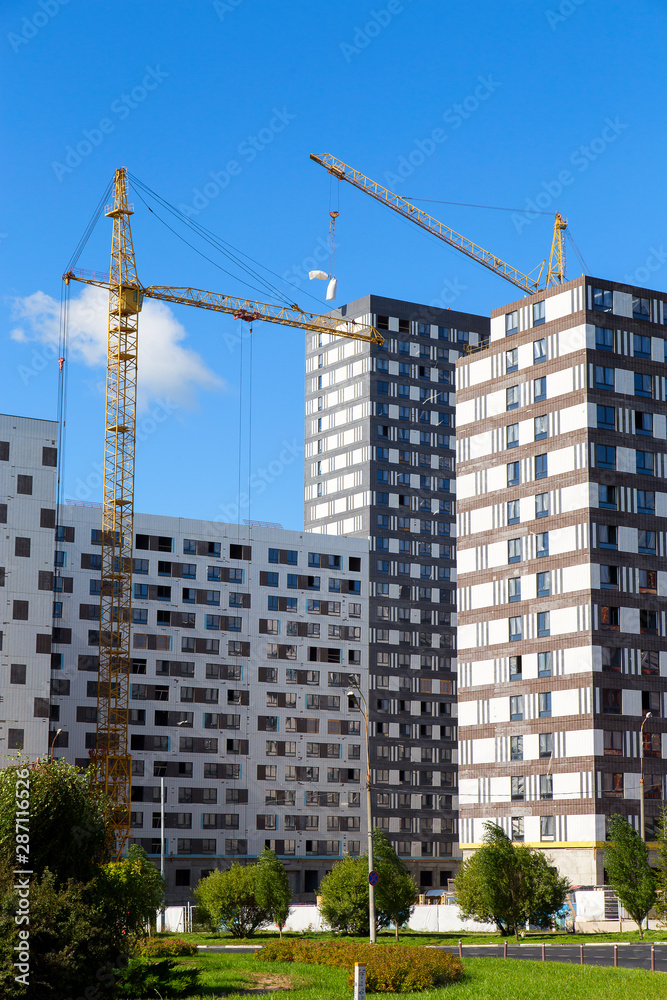 Cranes over the house under construction .Vertically. Cranes over the house under construction .Vertically.