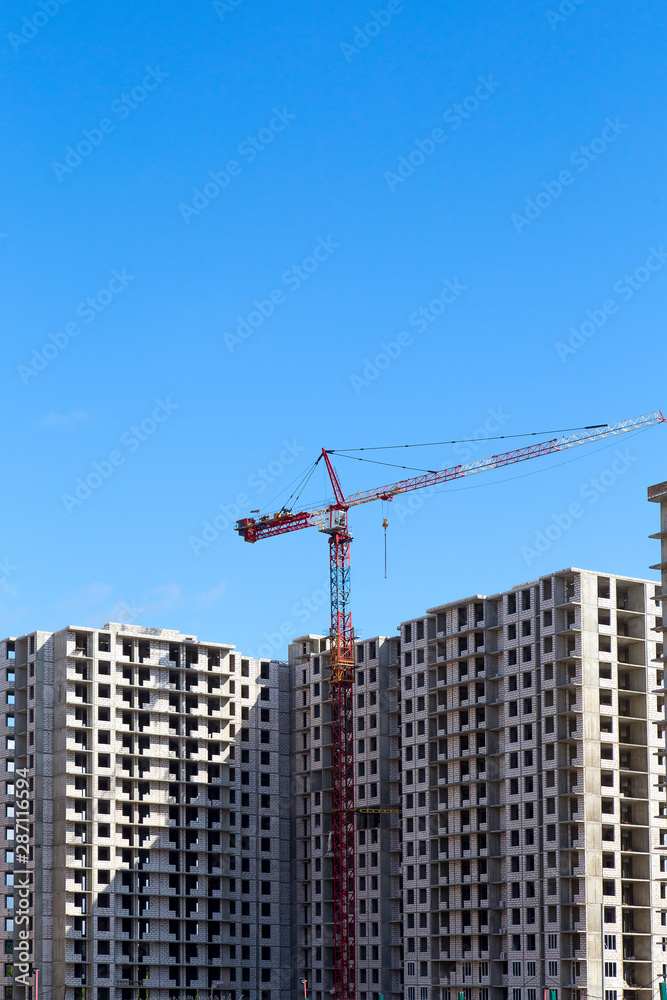 Cranes over the house under construction .Vertically. Cranes over the house under construction .Vertically.