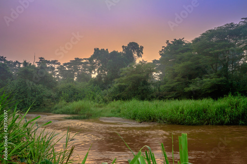 Sunrise view of Ishasha river, with trees growing and the reflections on the water, Queen Elizabeth National Park, Ishasha, Uganda, Africa photo