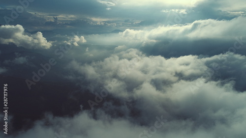 aerial fly above clouds with blue sky in backgroubnd on beautiful sunny day