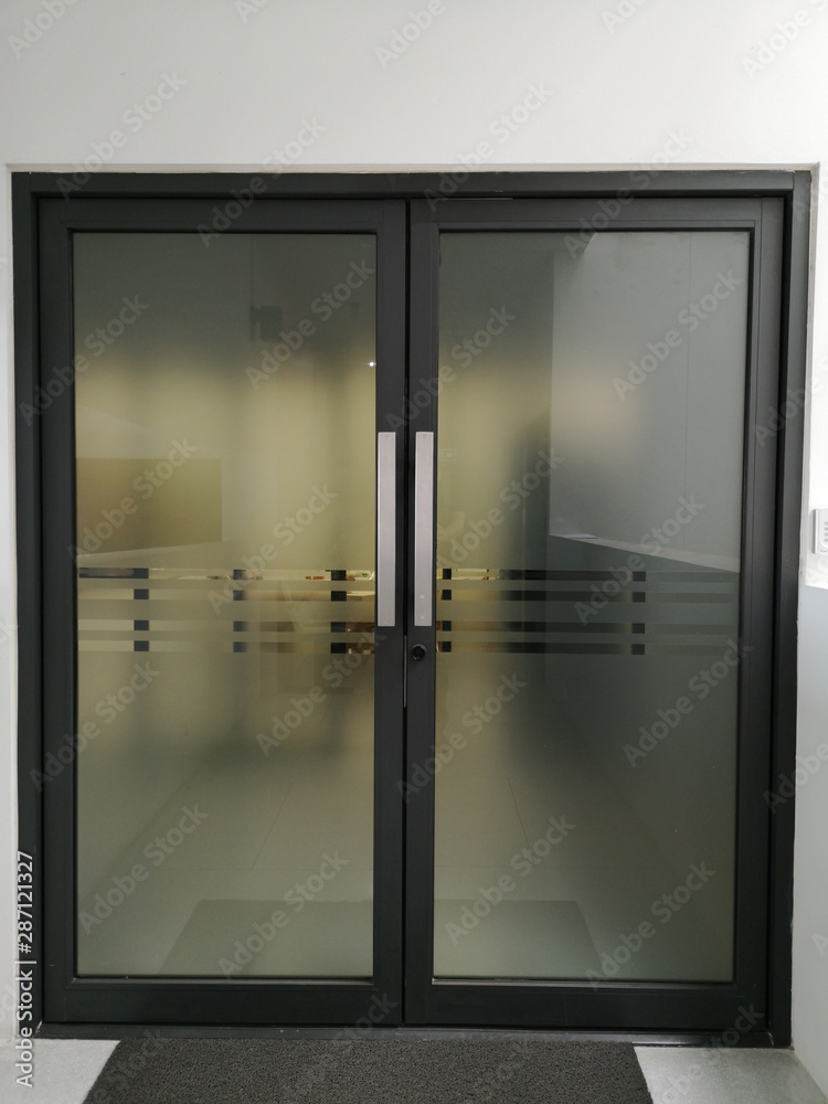 door is tinted with a black frame in the office building.