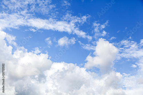 Stunningly blue sky with lots of clouds of different white and gray on a bright sunny day. Great texture of clouds and summer sky
