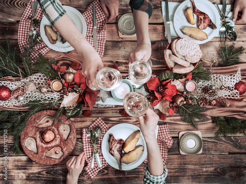 Flat-lay of friends hands eating and drinking together. Top view of people having party, gathering, celebrating together at wooden rustic table