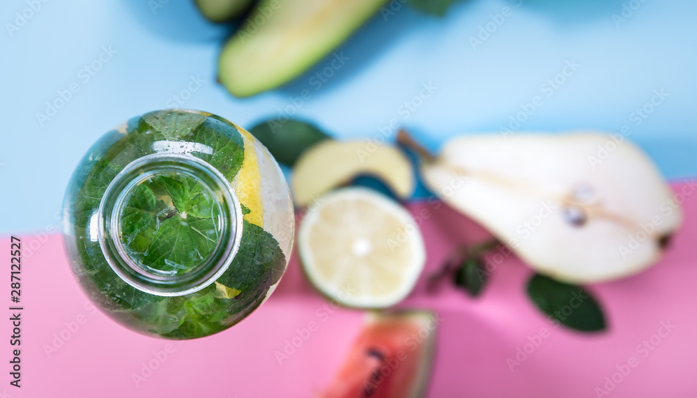 Glass bottles with natural drinks on a colored background Glass bottles with natural drinks on a colored background