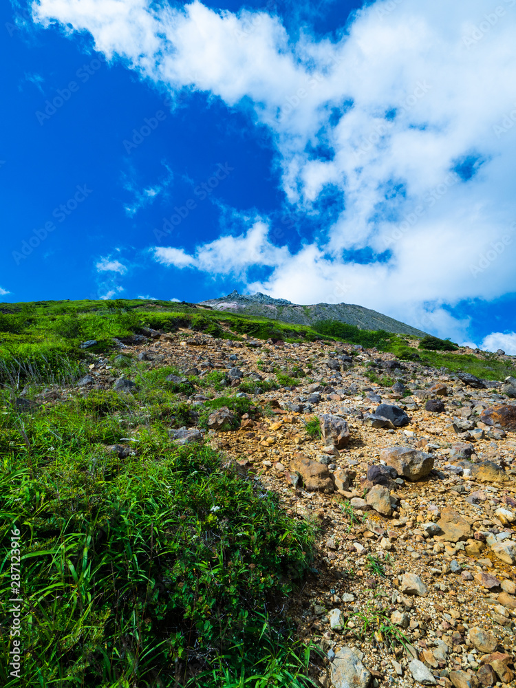 登山道から青空の中の那須茶臼岳を望む