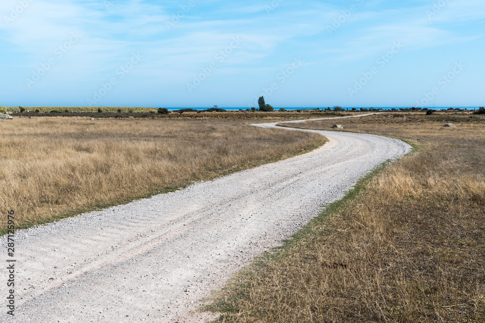 Winding gravel road in a barren landscape Winding gravel road in a barren landscape