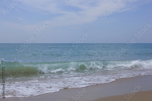 photograph of the sea and waves in clear weather, sandy beach