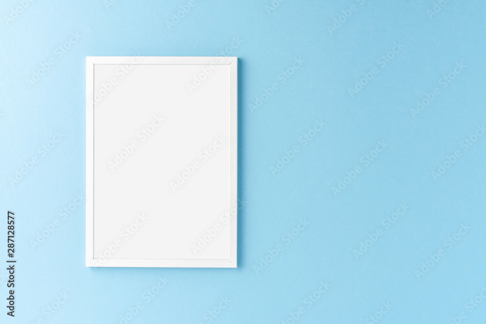 White photo frame with copyspace on blue background. Home decoration White photo frame with copyspace on blue background. Home decoration