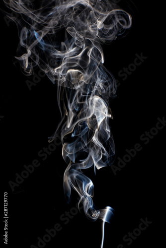 Abstract white smoke swirls on black background