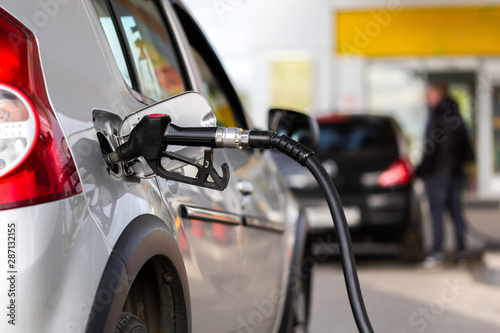 Canvas-taulu gray metallic car refueling on gas station - closeup with selective focus and bl