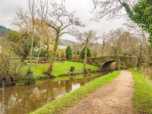 Monmouthshire & Brecon Canal , Brecon beacons national park in Wales, image of canal and towpath with old stone bridge used by farmers for moving livestock
