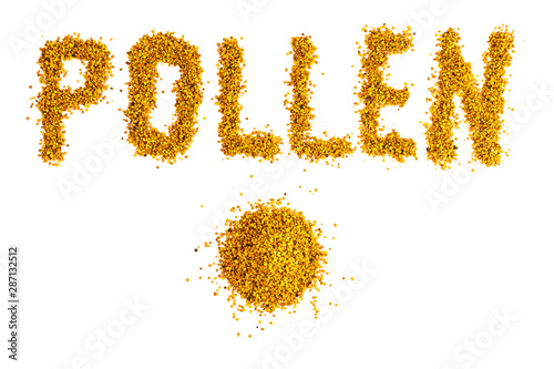 letters and small heap of bee pollen granules isolated on white background photo