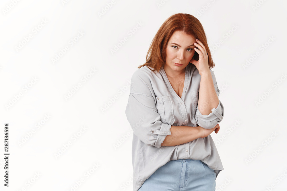 Stop it. Irritated displeased annoyed redhead middle-aged pressured woman touch temple look from under forehead scorn bothered cannot stand anymore displeased intense white background Stop it. Irritated displeased annoyed redhead middle-aged pressured woman touch temple look from under forehead scorn bothered cannot stand anymore displeased intense white background