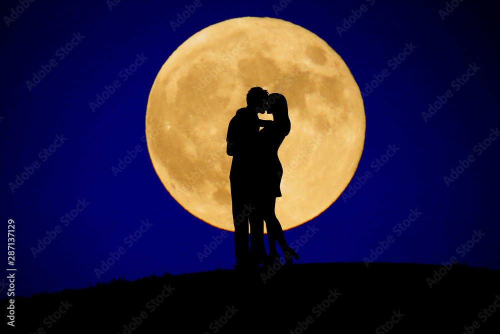 月をバックに立つカップル
