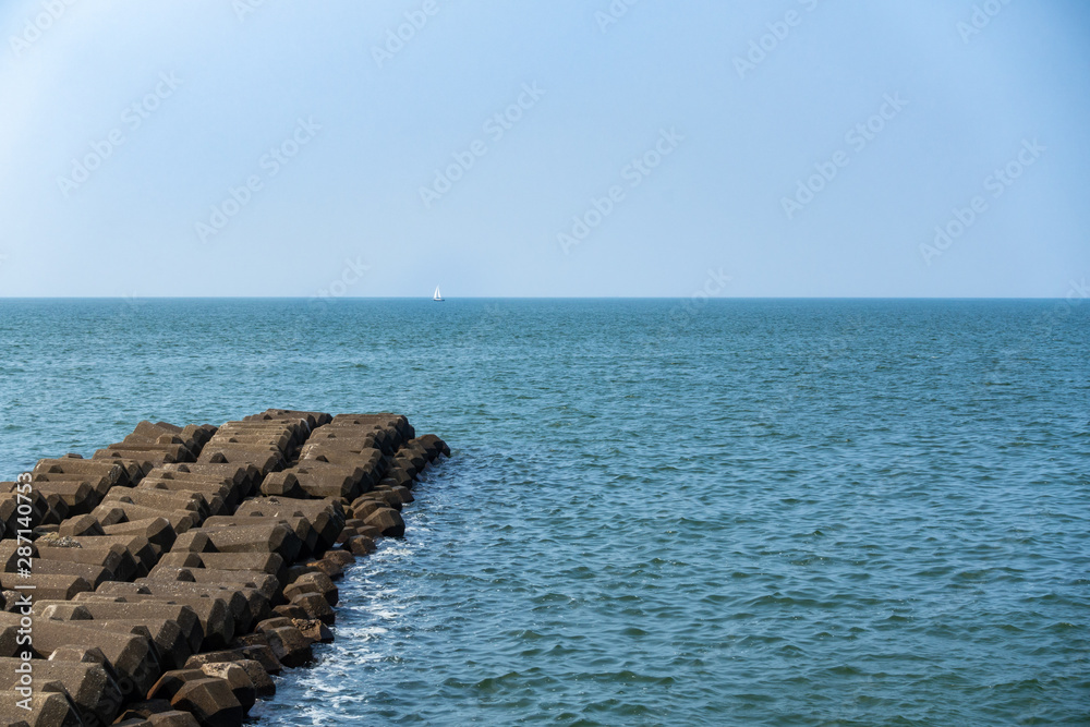 海と遠くに浮かぶヨットの写真 海と遠くに浮かぶヨットの写真