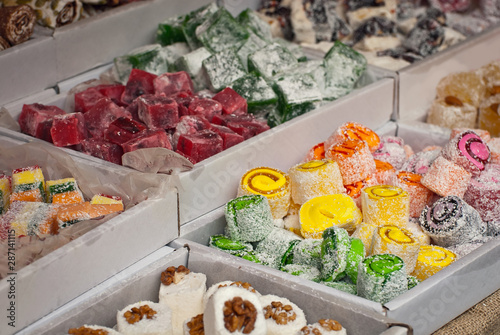 Turkish national sweets are sold at the fair. Multi-colored Asian desserts stacked on the table. Rahat lokum in bulk is sold at the festival.