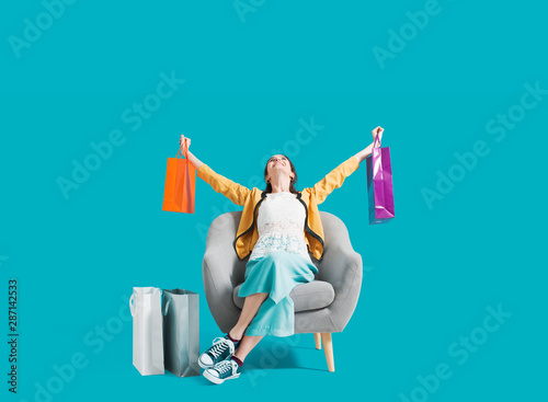 Cheerful shopaholic woman with shopping bags