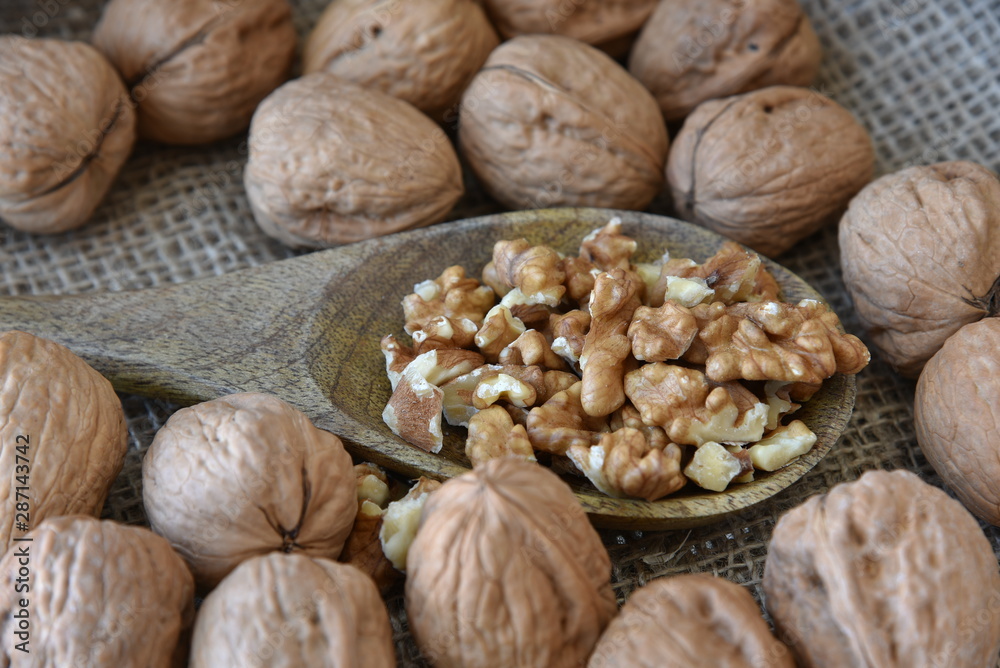 On burlap, peeled walnuts peeled on a wooden spoon. On burlap, peeled walnuts peeled on a wooden spoon.