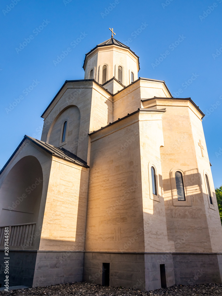 Fototapeta premium Exterior of Georgian Orthodox church in Kutaisi against blue sky in the morning.