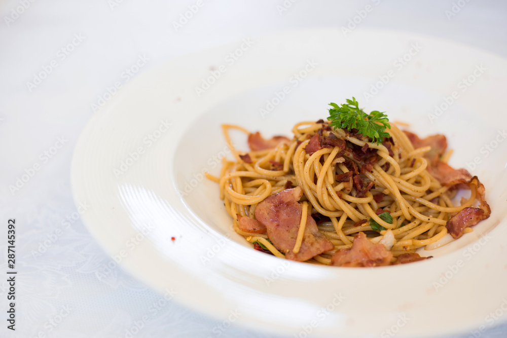 Stir-fried spaghetti spicy bacon, Asian fusion food traditional Thai style.