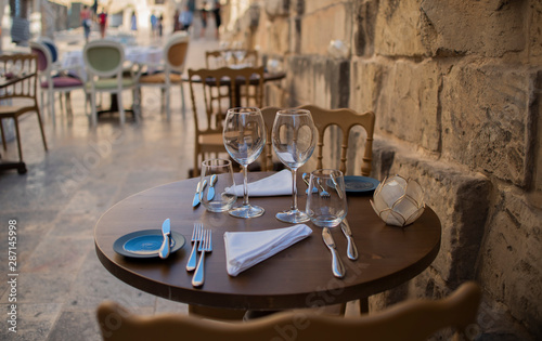 glasses are left on the table in a cafe, a stone wall