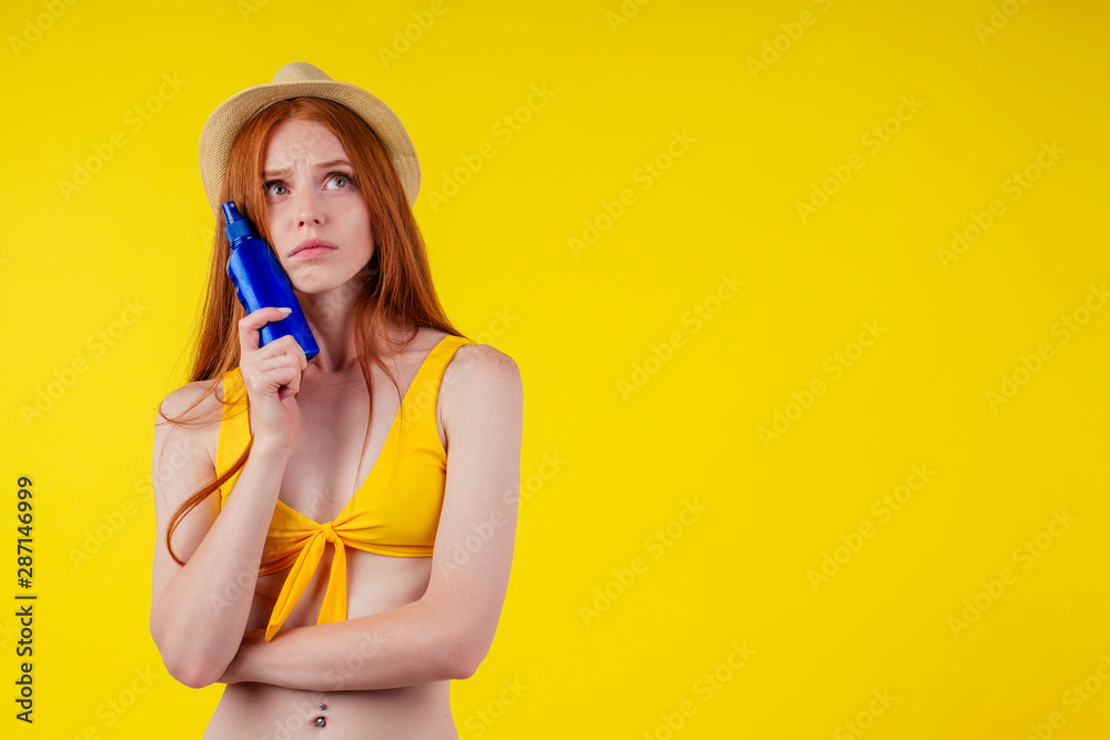 amazed redhaired ginger woman holding two plastic bottle of suncream,facial expression amazed redhaired ginger woman holding two plastic bottle of suncream,facial expression