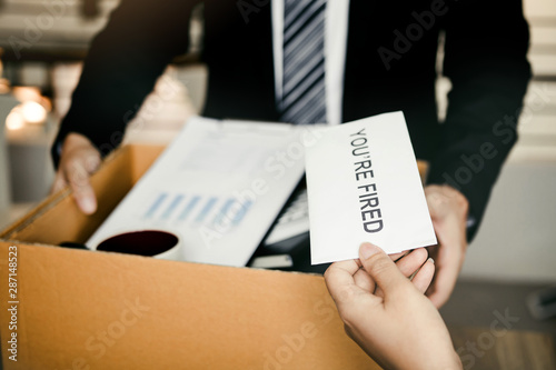 Female manager submits a resignation letter or envelope to the male employee at the office.