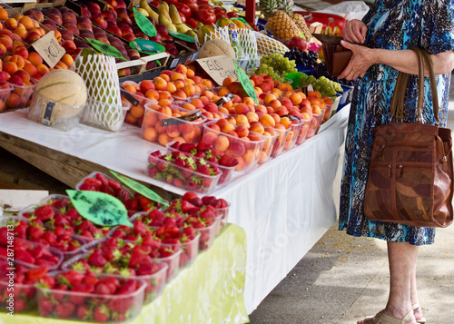 Eine junge Frau kauft einige Früchte auf einem Wochenmarkt