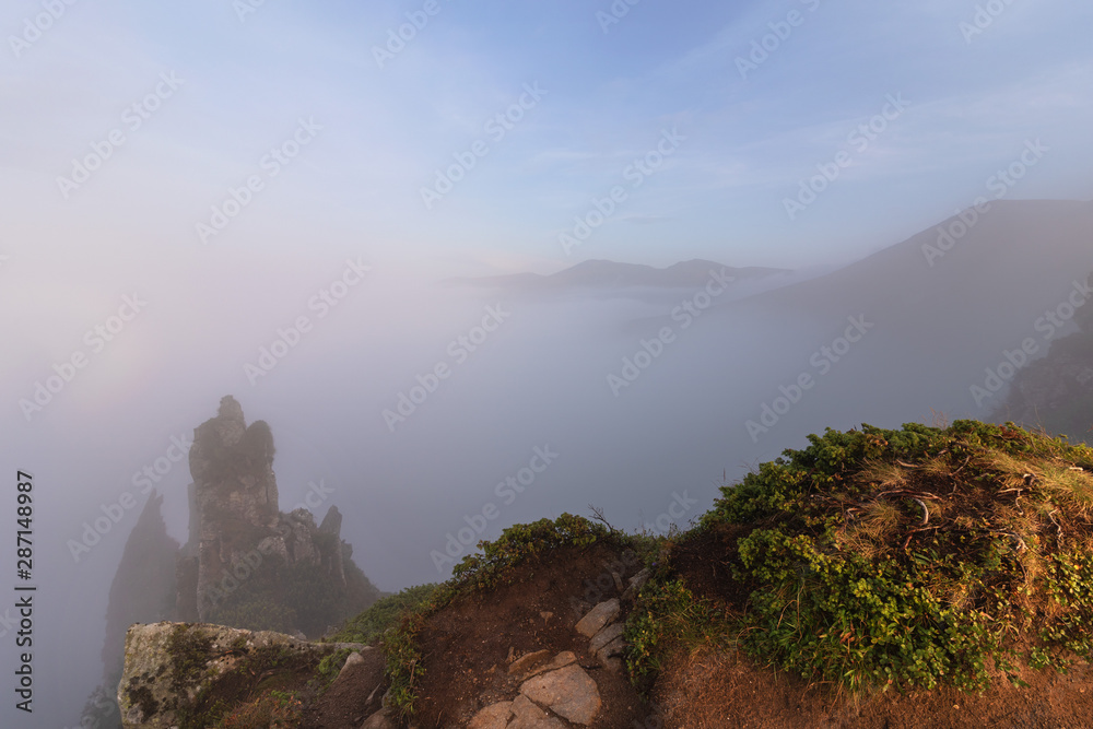 Landscapes of the Ukrainian Carpathian Mountains, with dramatic evening skies and mystical fogs among the rocks.