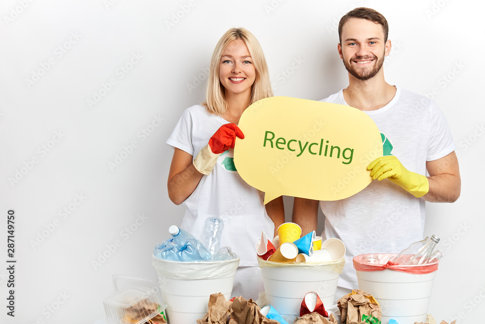 positive smiling young man and woman advising people to recycle waste, rubbish, close up portrait, studio shot, stop doing harm to our planet, volunteers require global action
