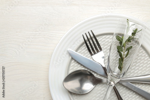 table setting. cutlery. Fork, knife, glass, spoon and plate on a white wooden table. top view