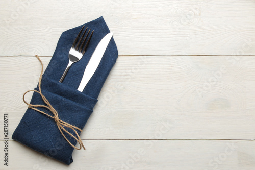 table setting. cutlery. Fork, knife in a blue napkin on a white wooden table. top view
