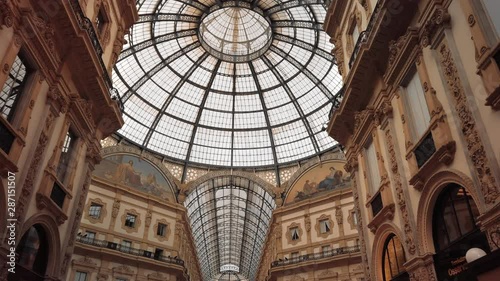 Milan, Italy - May 2019: Glass dome and interior gallery Vittorio Emanuele. The concept of shopping and expensive luxury stores. Slow motion, dolly shot.