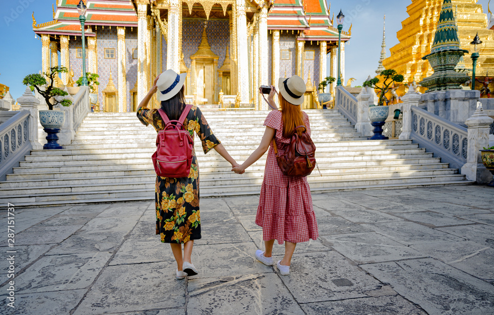 young tourist women walking through the palace temple in Bangkok of Thailand, Emerald Buddha Temple, Wat Phra Kaew, Bangkok Royal Palace popular tourist place young tourist women walking through the palace temple in Bangkok of Thailand, Emerald Buddha Temple, Wat Phra Kaew, Bangkok Royal Palace popular tourist place