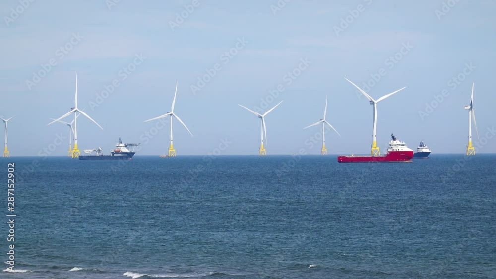 Sea wind farm turbines and ships in Aberdeen, renewable energy. Scotland