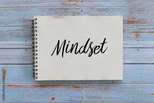 Photo Top view of notebook written with Mindset on wooden background.