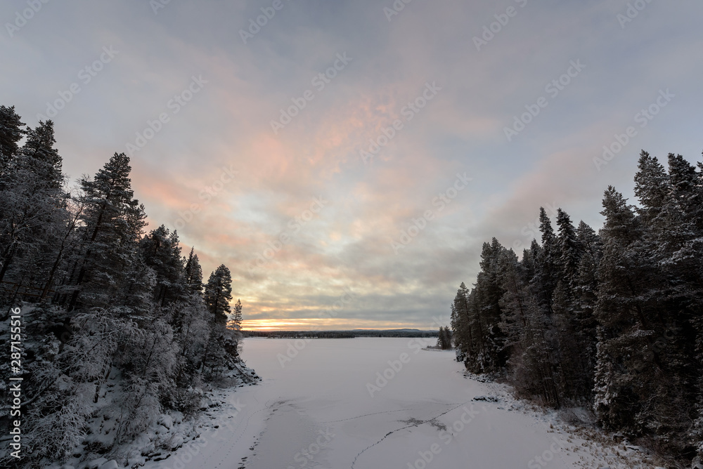 The ice lake has covered with heavy snow and sky in winter season at Oulanka National Park, Finland.
