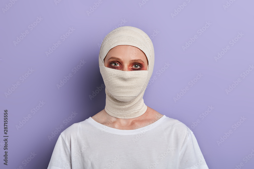 young woman has been saved by talented doctors after awful car accident. isolated blue background, studio shot