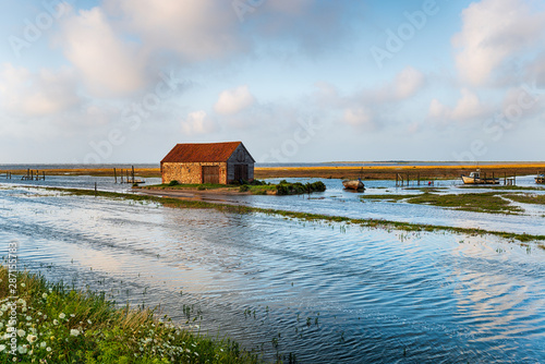 Tablou canvas Spring tides flooding the old harbour at Thornham