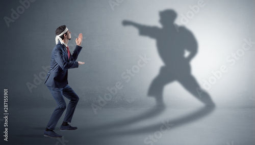 Businessman fighting with his strong karate man shadow photo