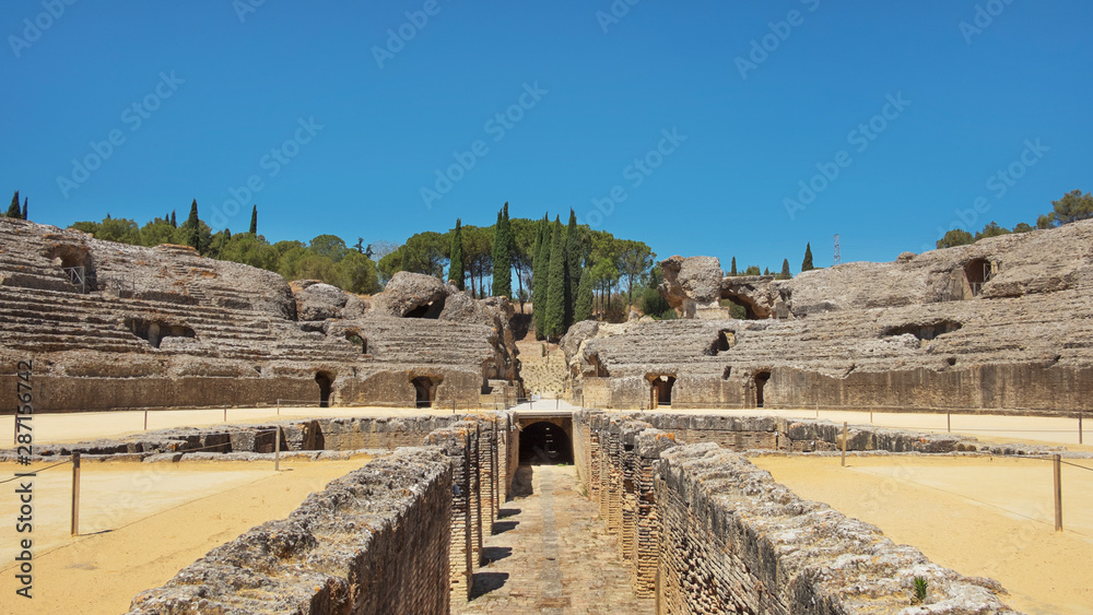 Ruins of the splendid amphitheater, part of archaeological ensemble of Italica, city with a strategic role in the Roman Empire, birthplace of Emperors Trajan and Hadrian, in Santiponce, Seville, Spain