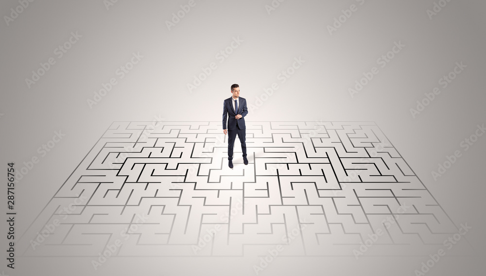 Elegant businessman looking for a solution in a middle of a maze Elegant businessman looking for a solution in a middle of a maze