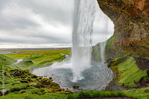 Seljalandsfoss waterfall in traditional Icelandic natural conditions - overcast weather. Point destination of Golden Circle great road trip in Icelanad.