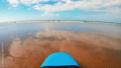 Ocean waves roll on the beach. Sunny day. Wet sand. Morocco. Atlantic ocean. Surf board.