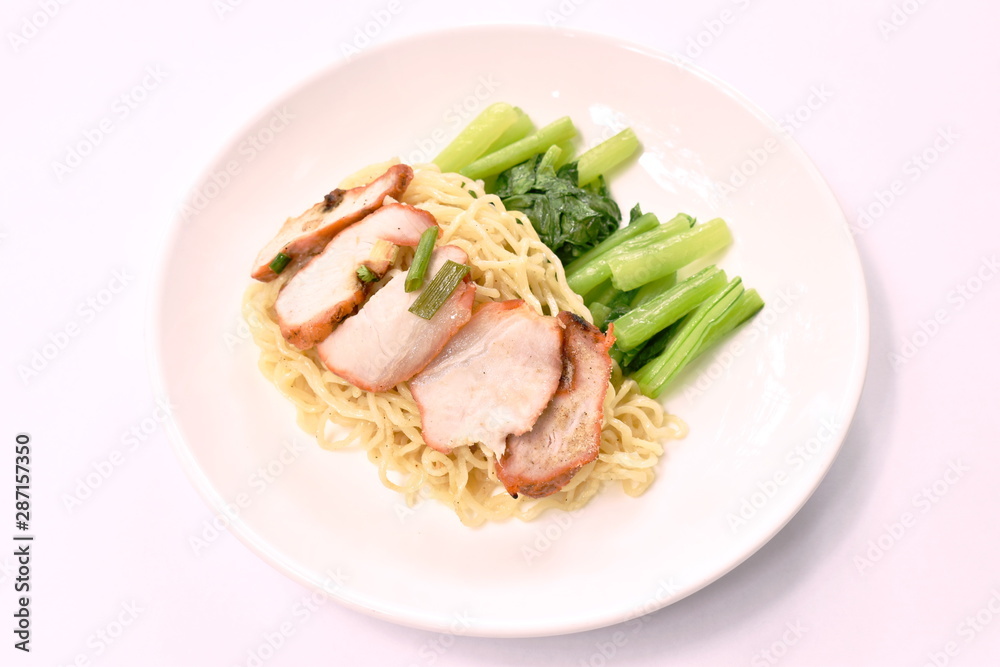 Chinese egg noodles topping slice roasted pork on plate