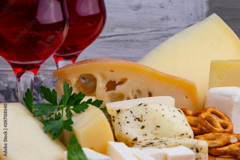 Different types of cheeses with wine glass. Close-up