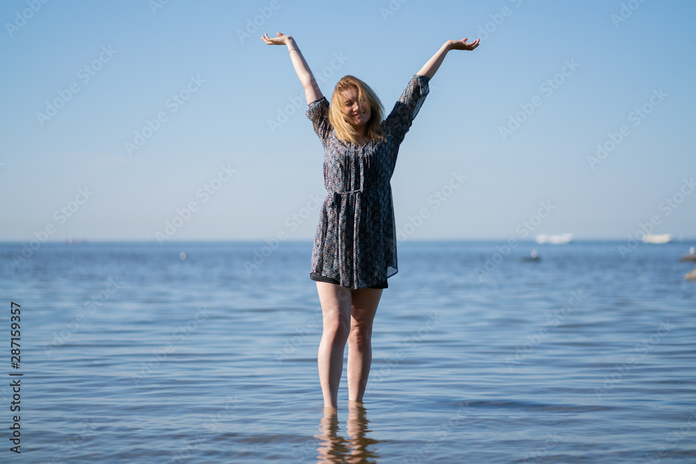 Attractive plus size woman in chiffon dress enjoys the shiny water in the blue sea Attractive plus size woman in chiffon dress enjoys the shiny water in the blue sea