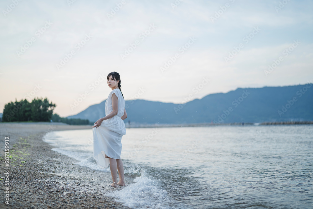 夕暮れの海の女性