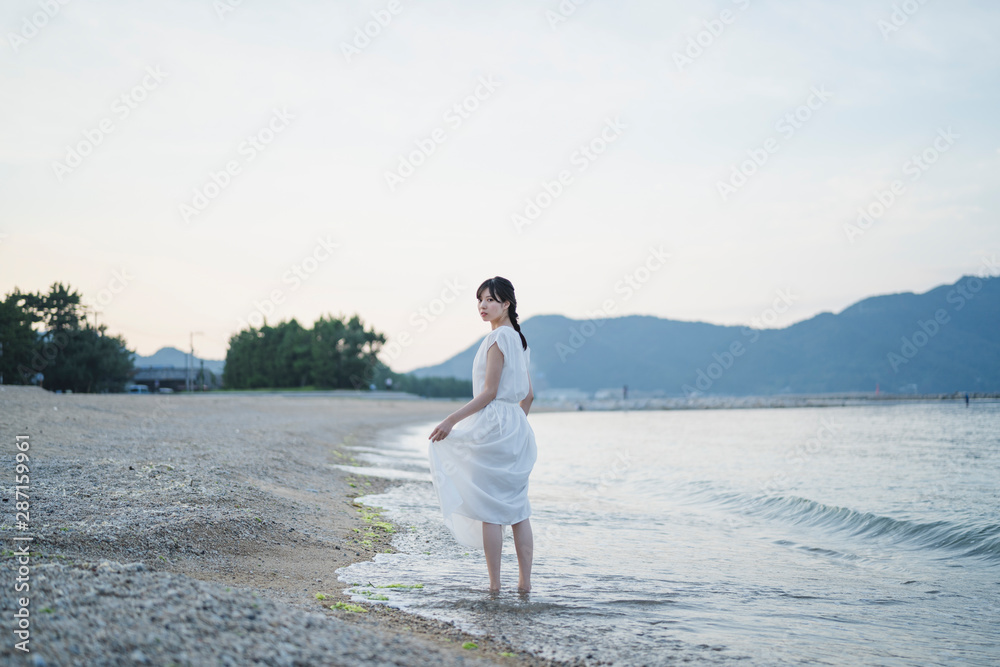 夕暮れの海の女性