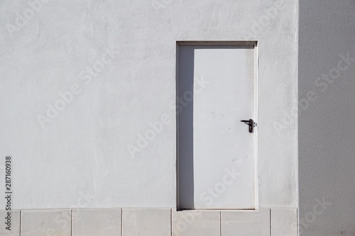 door on the white wall of the facade on the street